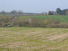 A few buildings scattered among fields and trees.