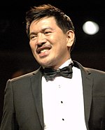 A photo of Brillante Mendoza in a suit and bow tie