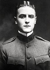 A picture of a hatless F. Scott Fitzgerald in his World War I military uniform taken in 1917. His tunic is fully bulleted, his golden hair is parted in the middle, and his white collar is starched.