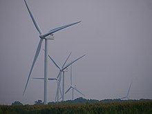Five turbines of the Scioto Ridge Wind Farm in a zoomed narrow-angle shot, some of which are partially below the horizon due to distance and topography.
