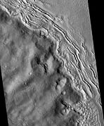 Hecates Tholus ridges, as seen by HiRISE. Ridges are to the west-northwest of Hecates Tholus. It has been proposed that this region was affected by a volcanic eruption that occurred under a 200 meter-thick ice sheet.[13]