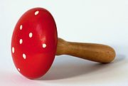 A classic red and white mushroom, only the stem is a brown wood and the top is a painted wood. Polka dots on the top of the red. The round shape is used for mending fabric