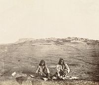 Zuni men and the ancient Pueblo Town of Zuni, c. 1868