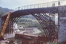 The Iron Bridge during the construction of the concrete inverted arch across the river bed, showing the cofferdam around the northern abutment and the concrete support already in place at the south
