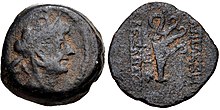 Coin of Alexander II. On the obverse, a bust of the king wearing a headdress in the shape of an elephant head. On the reverse, a ship aphlaston is shown