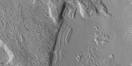 Close view of dipping layers along a mesa wall, as seen by HiRISE under HiWish program Location is Ismenius Lacus quadrangle.