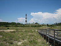 Walkway over dunes leading to a lighthouse