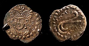 Coin in the name of Rakhanch, lord of Ushrusana. Tamgha symbol on the reverse with name of the ruler in Sogdian rγʾnč MRAY "Raxānič Afšīn".[1] Excavated in the Palace of Kala-i Kakhkakha I, Bunjikat. 7th century CE, National Museum of Antiquities of Tajikistan (RTL 213).[2] of Ushrusana
