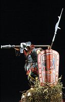 A model of a Hussite warrior behind a Pavise shield, carrying a píšťala on his arm