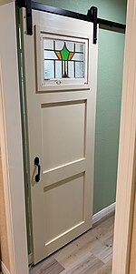 Sliding pantry door installed in a suburban home.