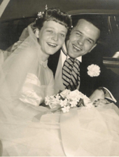 Stevens and his wife Ann on the day of their wedding, 1952. Stevens is in a suit, and Ann in a traditional bridal dress. Stevens and Ann both have wide smiles as she sits on his lap while he holds her, in what seems to be a car. The image has a light yellowish-sepiatone tint.