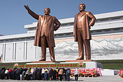 People bowing to statues of Kim Il Sung and Kim Jong Il.
