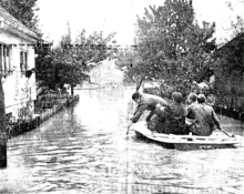 A group of soldiers rowing a small boat in a flooded street