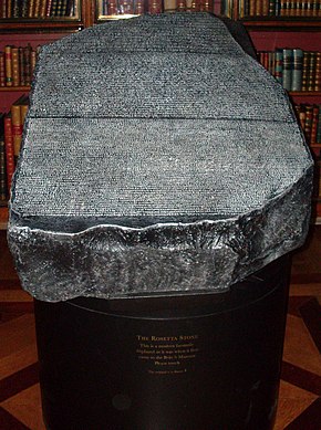 "Replica of the Rosetta Stone in the King's Library of the British Museum as it would have appeared to 19th century visitors, open to the air, held in a cradle that is at a slight angle from the horizontal and available to touch"
