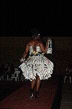 Fashion and Wellness shows a "Model showcasing a dress made out bulletin newspapers, this is an attempt towards clearing the environment and keeping it clean". This is from the theme "Health and wellness in Africa."