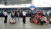 Passengers wait next to the Rajkot Express at Vadodara station