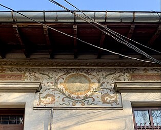 Beaux Arts fresco with cartouches and foliage spirals on the upper part of the facade of Strada Occidentului no. 11, Bucharest, painter: C. Cora, architect: Cesare Fantoli, 1910[16]