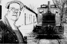 A man poses with a small locomotive at a train station
