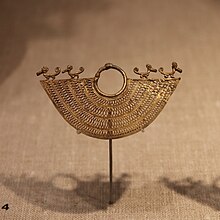 Zenú earring in the shape of a half moon, with elaborate filigree work