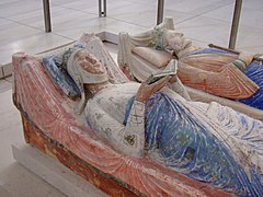 Tomb effigies of Eleanor (left) and King Henry (right). Eleanor is holding an open book, and Henry holds regalia. Both are crowned and resting.