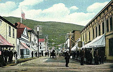 Dawson city in 1899. Modern houses, horse carriage and telegraph lines seen in street.