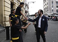 Nayib Bukele shaking hands with children dressed in bee costumes