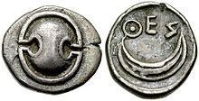 Photograph of an ancient Greek silver coin, showing a shield on one side.
