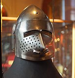 A medieval helmet with a pointed nose and narrow eye slits.