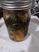 Homemade green kimchi, made with bok choy with a green onion and garlic scape-based chili paste