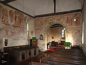 Interior of a church building with Romanesque paintings on the walls.