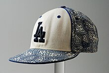 Cap with letters “LA” on the front, colors white and blue, brand “New Era”