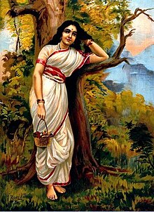 A painting of a young fair woman clad in a white sari with a red border stands, leaning on a tree, as she moves her left hand through her long black hair and holds a flower basket in her outstretched right hand.