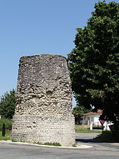 Photograph of an isolated stone tower in a modern setting