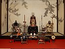 Gogatsu Ningyo from the Taishō era or early Shōwa era. Miniature armor in the ō-yoroi style (center), Samurai dolls featuring Shoki and Emperor Jinmu (back left and right), Samurai dolls wearing armor in the ō-yoroi and tosei gusoku styles (front)