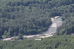 An aerial photo of the Stillaguamish River flowing in a dense coniferous forest