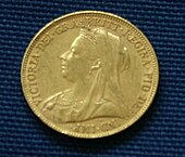 A gold coin, with the portrait of a veiled woman on it