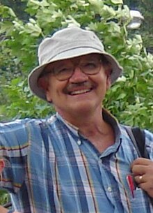 Ronald Powaski wearing a hat and flannel outdoors. He is smiling at the camera.