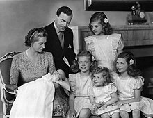 Family photo of a couple with four girls and a baby