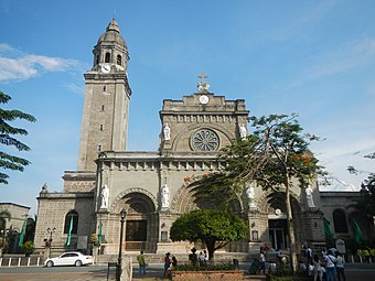 A cathedral in the Romanesque style with a large central portal, a wheel window, and a single, domed bell tower.