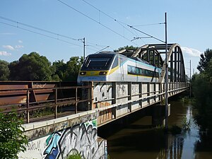 Silver train on bridge that crosses a river