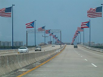 Close-up view of the bridge with its alternating American and Puerto Rican flags