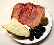 Bresaola della Valtellina served with bread, olives and onions