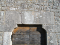 Die obere Hälfte des Portals mit Inschrift und Segmentbogen (Mai 2018).