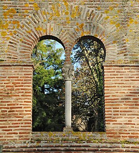 A brick window with carved capital in the Jardin des Plantes of Toulouse, France.
