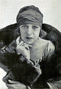 Lenglen posing and expressionless in her bandeau and coat