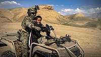 Commando on a Suzuku KingQuad with an Afghan boy near Mazar-e-Sharif.