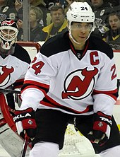 A defenseman in front of a goaltender during a game of hockey