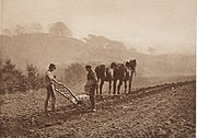 sepia color photogravure of a photograph of two men ploughing a field