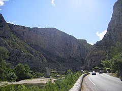 La route en direction de Saint-Jean-du-Gard et le pont ferroviaire sur le Gardon d'Anduze.