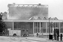The Norwich Central Library on fire in 1994, with a fire engine and firefighter in front.